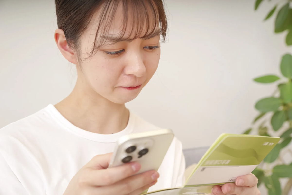 銀行通帳をみて落ち込む主婦